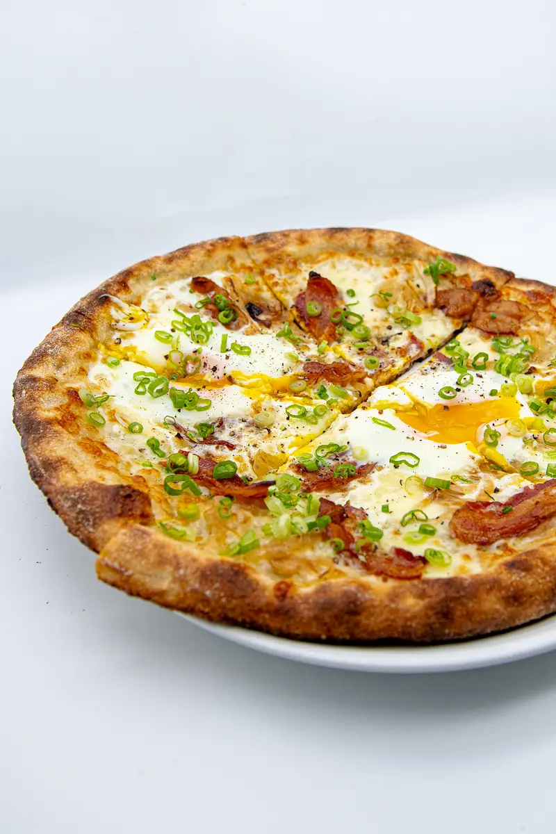 Breakfast pizza topped with eggs at Alfreda